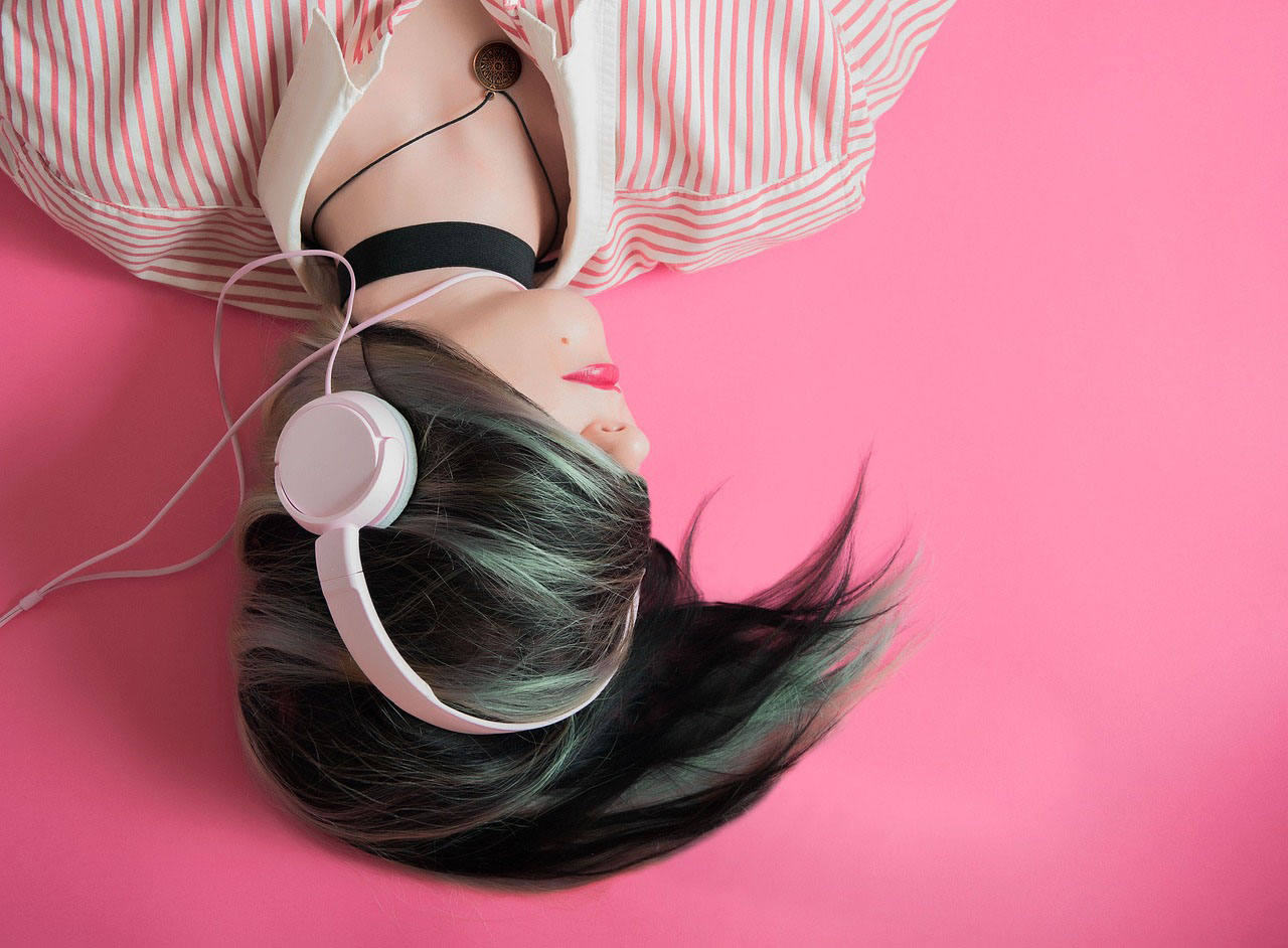 A woman listening to music on her headphones